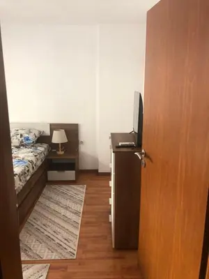 a bedroom with a bed and a desk with a television at При Бети in Sandanski