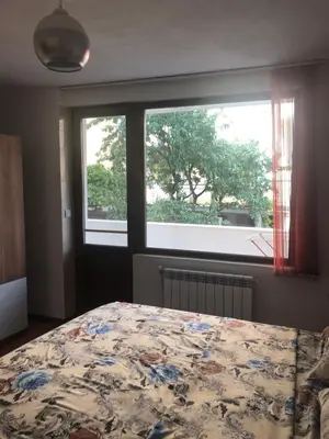 a bedroom with a bed in front of a window at При Бети in Sandanski