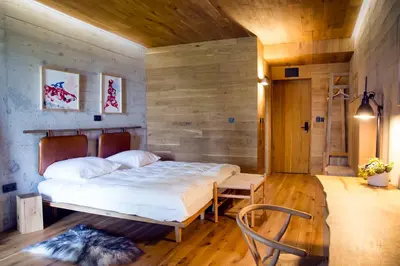 a bedroom with a bed and a wooden wall at Хотел Гела in Gela