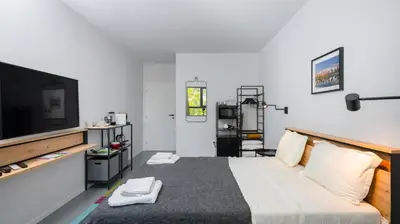 a bedroom with a bed and a flat screen tv at Aviva City Stay by Flat Mаnager in Sofia