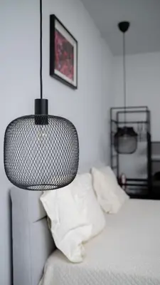 a lamp hanging over a bed in a bedroom at Aviva City Stay by Flat Mаnager in Sofia