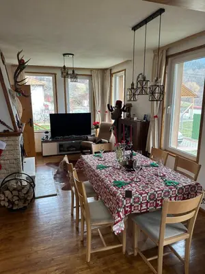 a dining room with a table and chairs and a television at Къща за гости Падалото in Smolyan