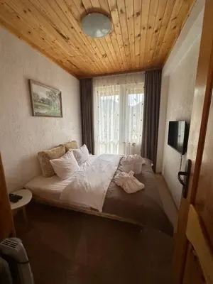 a bedroom with a large bed with a window at Къща за гости Падалото in Smolyan