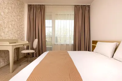 a hotel room with a bed and a desk at Magnolia Gardens -1BD with Balcony & Parking by Flat Mаnager in Plovdiv
