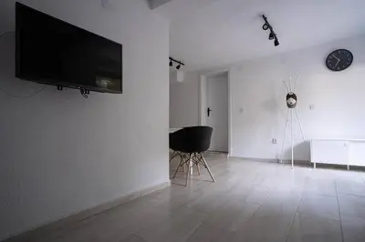 a living room with a flat screen tv on a wall at Студио Черно и Бяло in Sandanski