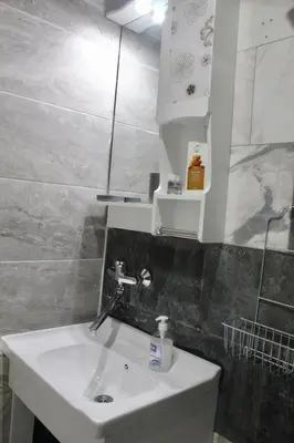 a bathroom with a white sink and a mirror at Apartment Near NDK Biairbnb in Sofia