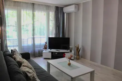 a living room with a couch and a tv at Apartment Near NDK Biairbnb in Sofia