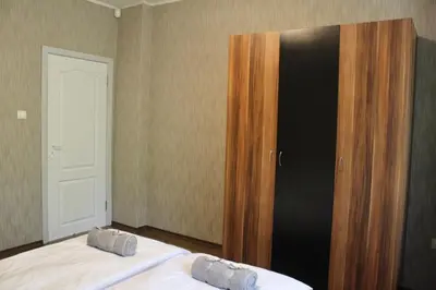a bedroom with a bed and a wooden closet at Apartment Near NDK Biairbnb in Sofia