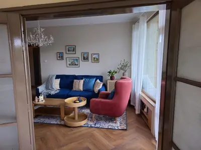a living room with a blue couch and a red chair at S íRMA Apartment - Amazing View of the Golden Domes in Sofia