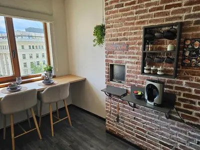 a room with a brick fireplace and a table and chairs at S íRMA Apartment - Amazing View of the Golden Domes in Sofia