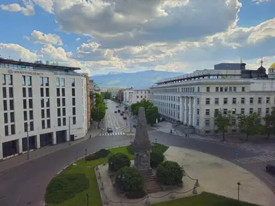 a city with a statue in the middle of a street at S íRMA Apartment - Amazing View of the Golden Domes in Sofia