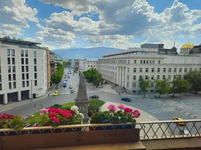 a view of a city with flowers on a balcony at S íRMA Apartment - Amazing View of the Golden Domes in Sofia