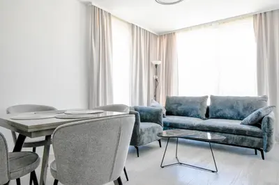 a living room with a couch and a table and chairs at Crème Lux - Elegant 1BD in Manastirski Livadi by Flat Manager in Sofia