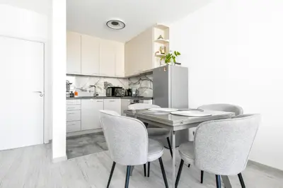 a kitchen with a wooden table and chairs at Crème Lux - Elegant 1BD in Manastirski Livadi by Flat Manager in Sofia