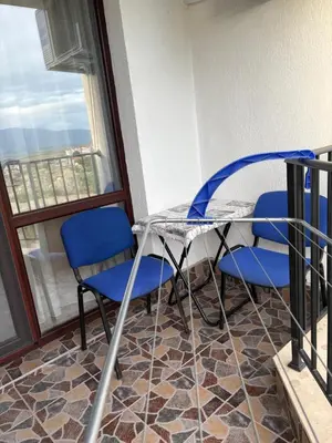 a table and chairs on a balcony with a window at Трушеви in Sandanski