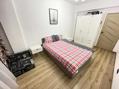 a small bedroom with a bed with a plaid blanket at Bulg Modern in Sofia