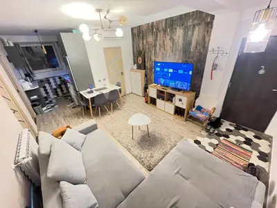 a living room with a couch and a tv at Bulg Modern in Sofia