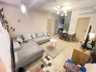 a living room with a gray couch and a table at Bulg Modern in Sofia