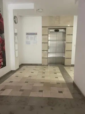 a hallway with a metal door and a tile floor at Park Residence in Sofia