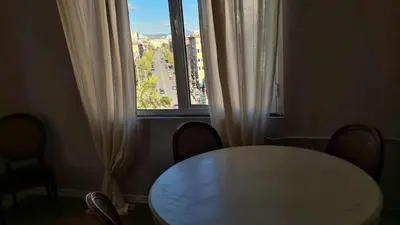 a table and chairs in a room with a window at Bright 2-BDRM - Stunning Views - Sofia Center in Sofia