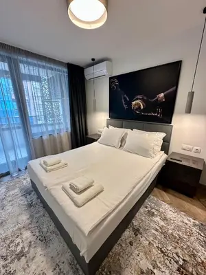 a bedroom with a large bed with two towels on it at Milea apartments in Sofia