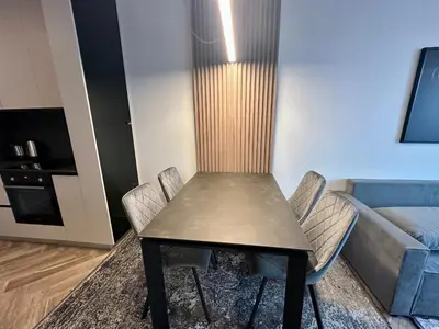 a table and chairs in a living room with a couch at Milea apartments in Sofia