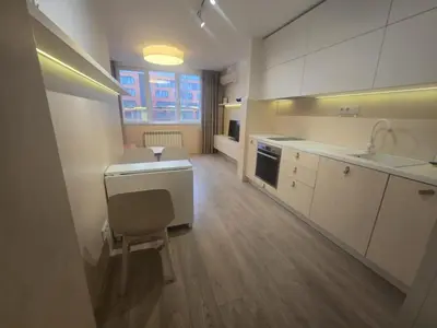 a kitchen with white cabinets and a sink and a chair at Paradise Stay & private parking in Sofia