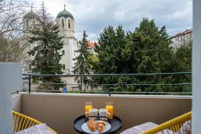 a table with a plate of food on a balcony at Luminous 2BDR with Balcony & View in the center in Sofia