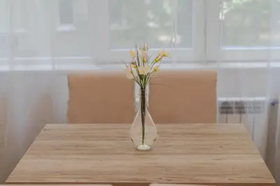 a vase with yellow flowers in it on a table at Luminous 2BDR with Balcony & View in the center in Sofia