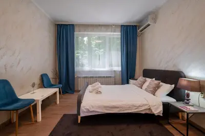 a bedroom with a bed and two chairs and a window at Luminous 2BDR with Balcony & View in the center in Sofia