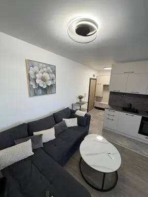 a living room with a blue couch and a table at Nikea apart 1 in Velingrad