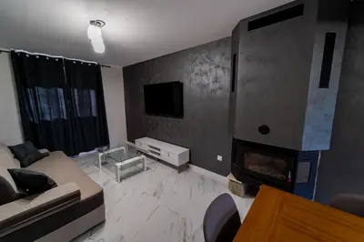 a living room with a couch and a fireplace at Къща за гости Катлея in Hisarya