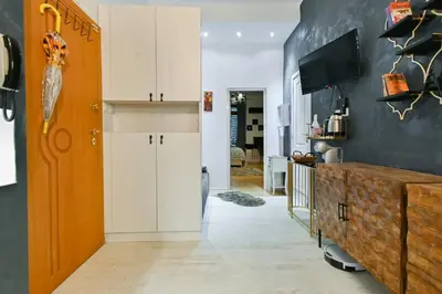 a kitchen with white cabinets and a tv on a wall at Luxory in Sofia