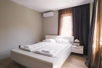 a white bed in a bedroom with a window at Iztok House Apartment in Sofia