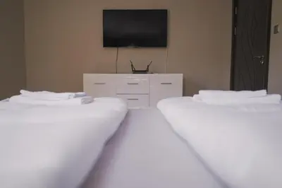 a room with two beds and a flat screen tv at Iztok House Apartment in Sofia