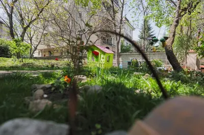 a small yellow house in the middle of a yard at Iztok House Apartment in Sofia