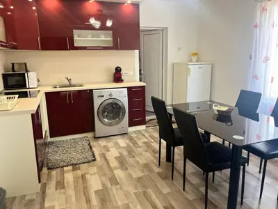 a kitchen with a table and a washing machine at Речен шепот in Kalofer