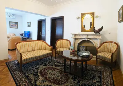 a living room with a table and chairs and a fireplace at The Executive Escape Sofia in Sofia