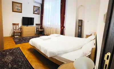 a bedroom with a white bed and a tv at The Executive Escape Sofia in Sofia