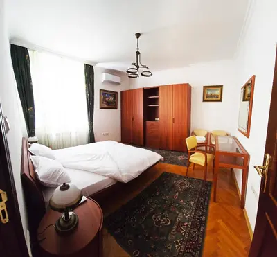 a bedroom with a bed and a desk and a table at The Executive Escape Sofia in Sofia