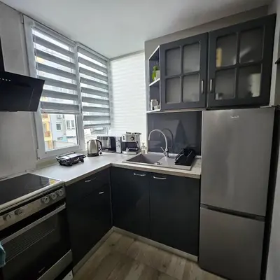 a kitchen with black cabinets and a stainless steel refrigerator at Philipopolis Stay in Plovdiv