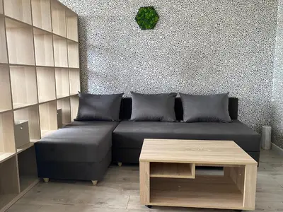a living room with a black couch and a table at Панорама in Panagyurishte