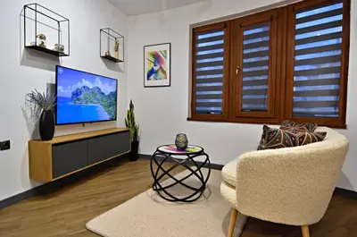 a living room with a television and a chair at Oblivion in Velingrad