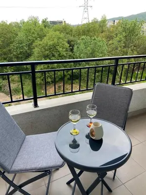 a table with two glasses and two chairs on a balcony at Sofia Park View Apartment in Sofia