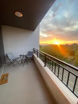 a balcony with a table and chairs and a sunset at Sofia Park View Apartment in Sofia