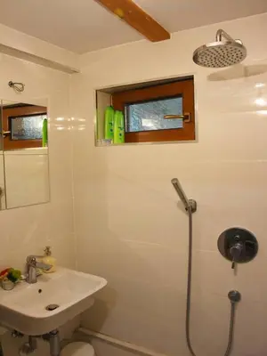 a white bathroom with a sink and a shower at Anna's downtown loft in Plovdiv