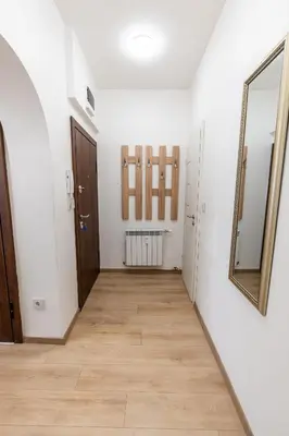 a hallway with white walls and a mirror at Finest 3BR Downtown in Sofia