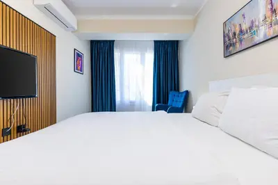 a bedroom with a white bed and a tv at Central Chic 1BD Apt Near Kapana by Flat Manager in Plovdiv