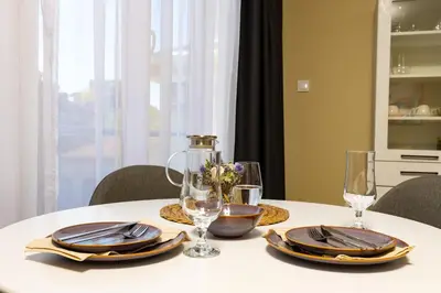 a white table with plates and glasses on it at Central Chic 1BD Apt Near Kapana by Flat Manager in Plovdiv