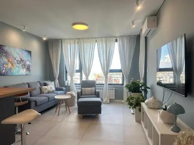 a living room with a blue couch and a tv at Апартамент В 48 в Сграда МОНА in Sofia